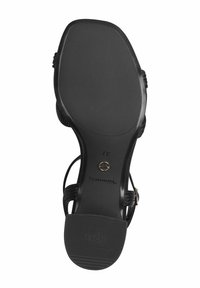 Svart sandal med sula i texturerad gummi och präglad logotyp. Har ett remdesign och en liten cirkulär metallaccent. Storlek 37.