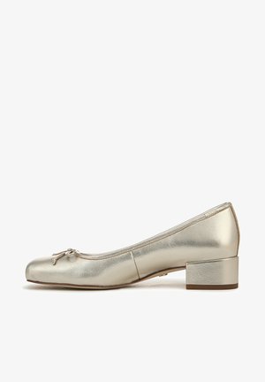 Ballet flat dorato metallico con punta rotonda, tacco a blocco piccolo e un fiocco decorativo sulla parte superiore. La texture liscia enfatizza la brillantezza.