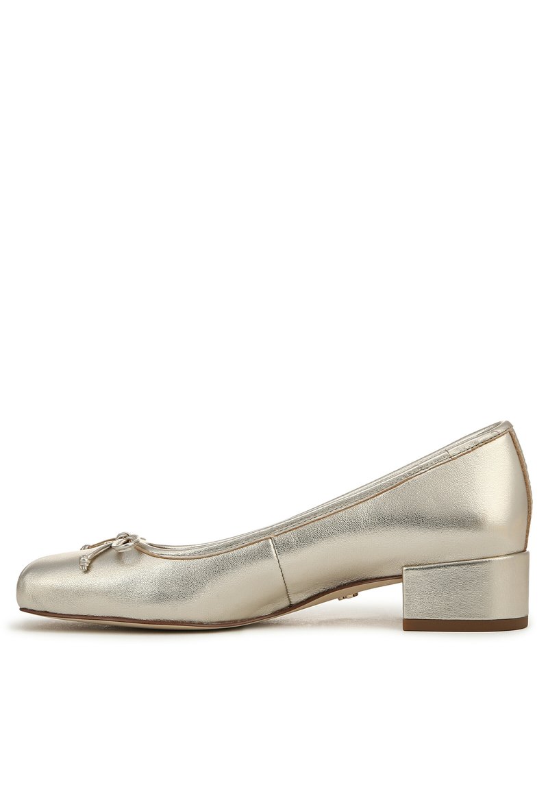 Ballet flat dorato metallico con punta rotonda, tacco a blocco piccolo e un fiocco decorativo sulla parte superiore. La texture liscia enfatizza la brillantezza.