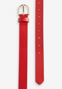 Ceinture en cuir rouge avec une boucle en métal doré, présentant une texture lisse, des trous espacés régulièrement et une extrémité effilée.