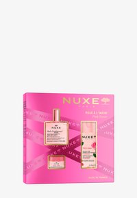 NUXE presentlåda i en rosa box innehåller tre produkter: en flaska med rosa olja, en flaska med rosa micellärt vatten och en krämkruka med blommönster.