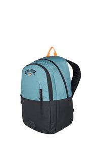 Mochila verde azulado y negra con correas acolchadas, dos bolsillos frontales con cremallera y un asa superior naranja. Cuenta con un logo en la parte delantera.
