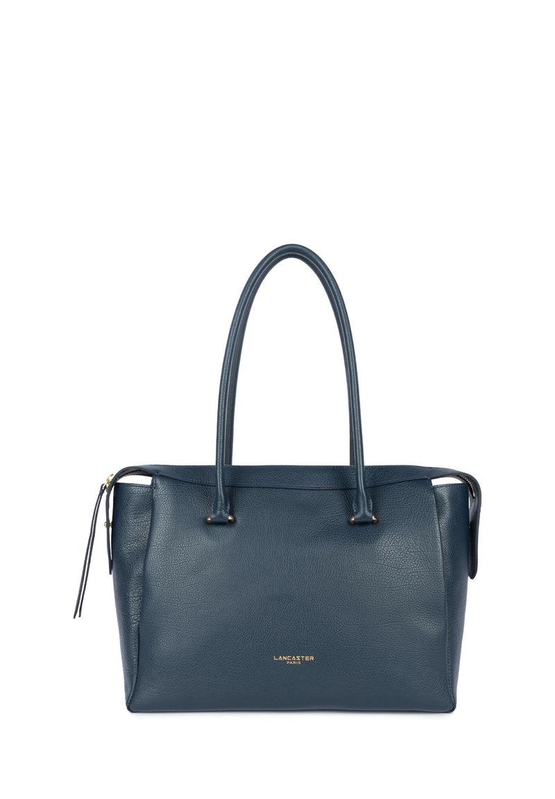 Donkerblauwe leren totebag met twee handvatten, ritssluiting en een goudkleurig logo aan de voorkant. Gestructureerd oppervlak met een minimalistisch ontwerp.