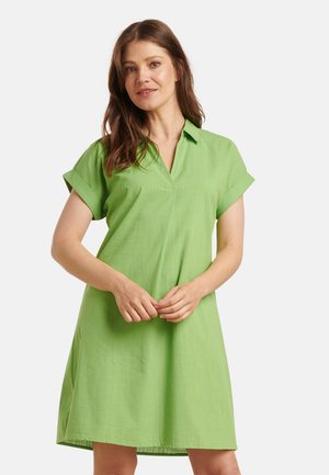 Grünes Kleid mit umgeschlagenen Ärmeln, gefertigt aus leichtem Stoff. Das Design ist einfach und hat einen V-Ausschnitt.