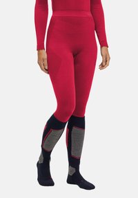 Rote thermische Leggings mit strukturierten Einsätzen, hoher Taille und schwarzen Kniestrümpfen mit grauen Akzenten und geometrischen Mustern.