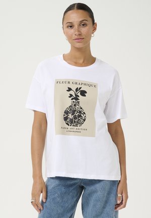 T-shirt graphique blanc avec un design imprimé en beige et noir représentant un vase avec des éléments floraux. Coupe décontractée avec des manches courtes.