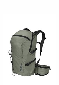 Backpack in muted green fabric with black accents, featuring a textured surface, adjustable straps, side pockets, and exterior bungee cords.