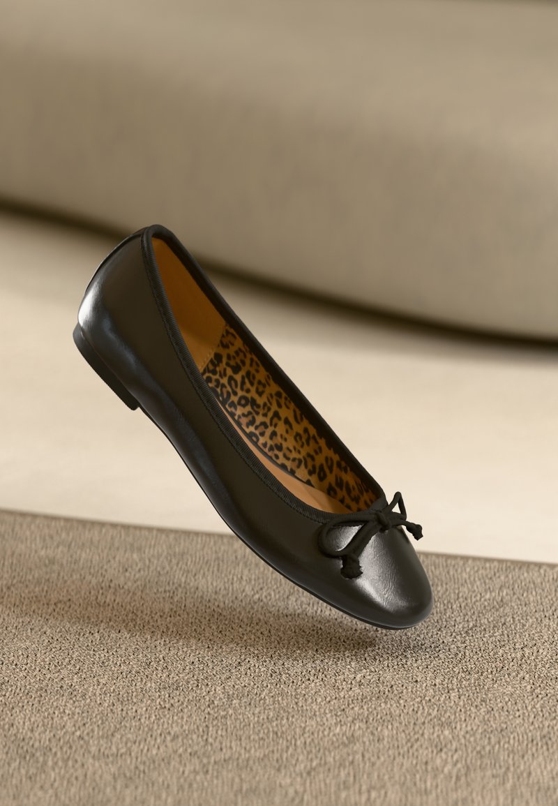 Čierne kožené baletné baleríny s okrúhlou špičkou a látkovým mašľou, vnútorná strana s leopardím vzorom. Hladká textúra a štíhly profil.