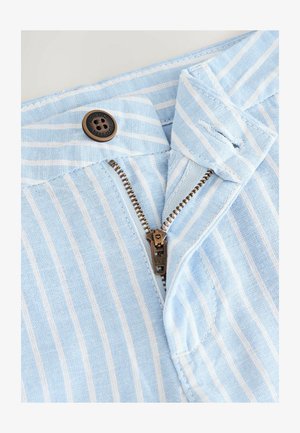 Šviesiai mėlynas audinys su baltomis juostelėmis, turintis užtrauktuką ir bronzinį mygtuką, pažymėtą "Autentiškas Next Dude".