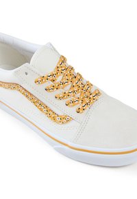 Baskets en toile crème avec une finition en daim, lacets jaunes à motif floral et semelle en caoutchouc blanche. Accent jaune sur le côté.