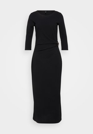 Czarna sukienka z długim rękawem i okrągłym dekoltem, z detalem w postaci skręcenia w talii, zabezpieczonym złotym akcentem, sięgająca do podłogi.