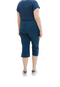 Námořnické modré capri kalhoty vyrobené z hladké, lehké látky. Mají uzpůsobený pas, zadní kapsy a design zkrácených nohavic.