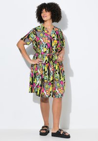 Abito a maniche corte con un motivo floreale e astratto colorato, vita cin cinata con un nastro e una silhouette A-line rilassata.