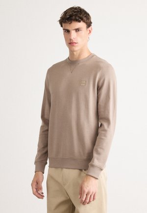 Bruine sweatshirt met lange mouwen, ronde hals en een klein logo op de borst. Gemaakt van zacht materiaal met ribbelmanchetten en -zoom.