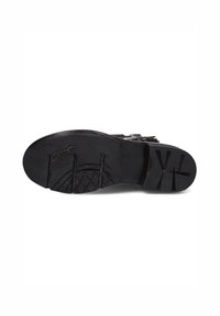 Black rubber shoe sole with textured grip pattern, featuring embossed logo details and a smooth finish. Wide, rounded toe design.