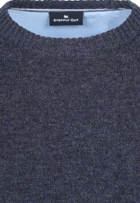 Gebreid marineblauw sweater met een geribbelde ronde hals. Zachte textuur met subtiele kleurvariaties, met een label waarop "STEPPIN' OUT" staat.