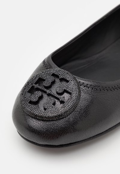 Les ballerines en cuir noir présentent un logo rond et texturé sur le bout, une finition lisse et un design à profil bas avec des détails de surpiqûre subtils.