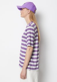 Purple and white striped short-sleeve t-shirt made of soft fabric, featuring a round neckline. Paired with a matching purple cap.