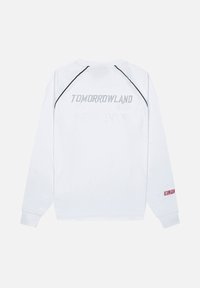 Witte langarmshirt met een ronde hals, voorzien van een vervaagde "TOMORROWLAND" logo in grijs op de achterkant en een rode accent op de mouw.