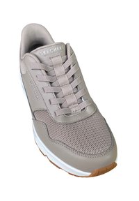 Sneaker da uomo Skechers di un beige chiaro con tomaia in rete, lacci elastici, colletto imbottito e suola in gomma. Intersuola bianca e dettagli testurizzati.