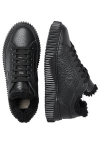 Zwarte leren sneakers met een gestructureerde bovenkant, ronde neus, contrasterende mesh veters en een dikke ribbelzool met een pluizige kraagafwerking.