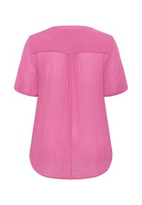 Blouse rose à manches courtes avec une texture lisse, un col arrondi et un détail plissé à l'arrière. L'ourlet est légèrement arrondi.