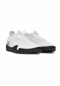 Zapatillas deportivas blancas con una parte superior de malla texturizada, suela de goma negra y acentos contrastantes; presentan un branding mínimo y un sistema de cierre de cordones.