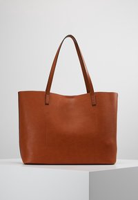 Bruine leren tote bag met een gladde textuur, open bovenkant, lange handvatten en een subtiele externe zak. Rechthoekige vorm, ruime indeling.