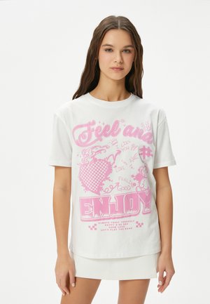 Hvid bomulds t-shirt med lyserøde grafiske tekster og illustrationer, inklusive hjerter og legende motiver, i en afslappet pasform.