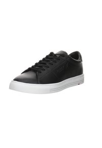 Baskets en cuir noir avec une finition lisse, semelle en caoutchouc blanc, bout rond et six œillets pour les lacets. Présente un branding subtil sur le côté.
