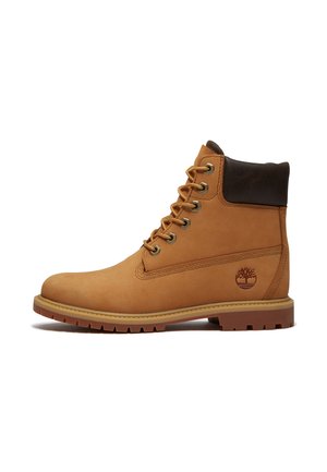 Arbeidsstøvel i lyst brunt skinn med snøring, polstret mørk brun krage, gummisåle og Timberland-trelogo på siden.
