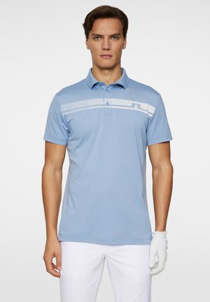 Light blue polo shirt made of smooth fabric, featuring a white horizontal striped pattern across the chest and a collared neckline.