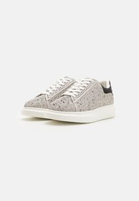 Baskets argentées avec un dessus texturé, présentant des embellissements brillants, des lacets blancs et une semelle blanche solide. Accents noirs au niveau du talon.