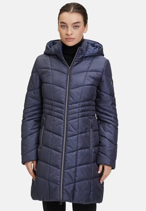 Geplüschter Reißverschlussmantel in tiefem Marineblau mit einer Kapuze. Verfügt über ein geometrisches Steppmuster, seitliche Taschen und lange Ärmel. Geschmeidige Textur.