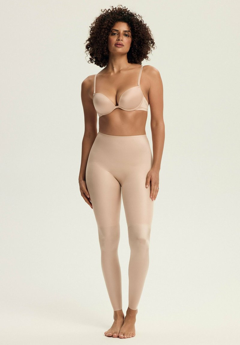 Nude, bezszwowy zestaw bielizny składający się z usztywnianego biustonosza z regulowanymi ramiączkami oraz spodni legging z wysokim stanem, które idealnie przylegają do ciała i mają gładką fakturę.