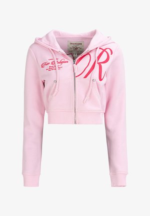 Lichtroze cropped zip-up hoodie met zakken aan de voorkant, trekkoorden en een rood "True Religion" logo borduursel op de borst en schouder.