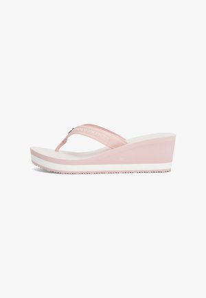 Roze wig flip-flop met een gestreepte stoffen band, witte zool en verticale ribbels op de binnenzool voor grip en comfort.