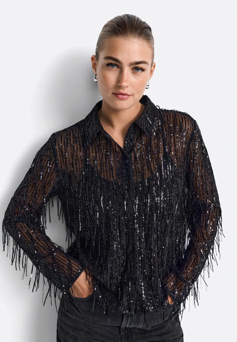 Cămașă neagră cu paiete, având detalii cu franjuri, cu guler și mâneci lungi. Material transparent cu un finisaj texturat.
