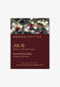Emballage de bougie parfumée Skandinavisk Jul avec texte doré sur fond bourgogne, arrière-plan festif bokeh, décrivant les rituels, la mythologie et la cire de colza suédoise.
