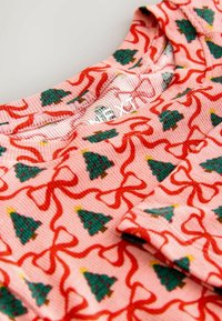 Rosa Stoff mit gerippter Textur, verziert mit einem Muster aus grünen Weihnachtsbäumen und roten gewundenen Bändern. Runder Halsauschnitt.