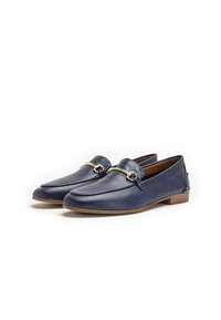 Mocasines de piel azul marino con un acabado suave, un detalle decorativo de hardware en tono dorado y un tacón bajo de madera para mayor comodidad.