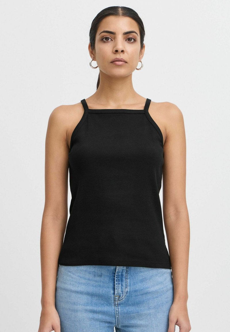 Must mustriba tank top musta värviga, kitsaste rihmade ja ruudu kujuga kaelusega, kombineeritud heledate siniste teksapükstega. Lihtne, sobiv disain.