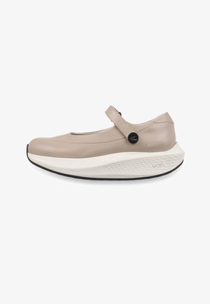 Chaussure Mary Jane beige avec une semelle extérieure épaisse et blanche texturée, une semelle extérieure noire et une bride unique fermée par un bouton noir sur le côté.