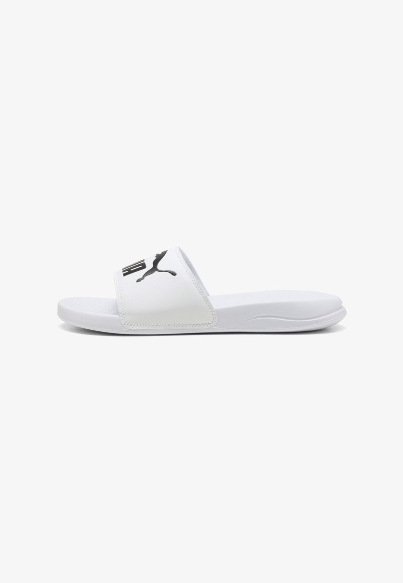 Sandale blanche à enfiler avec un logo Puma noir sur une large bride et une semelle contournée pour un usage décontracté.