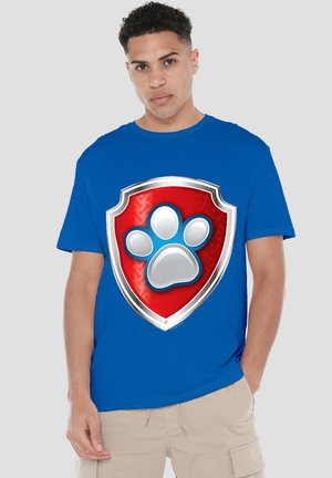 Blaues Baumwoll-T-Shirt mit einem großen roten Schildmotiv mit silbernem Rand und einem weißen Pfotenabdruck in der Mitte. Kurzarm, Rundhals.