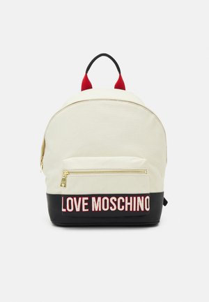Sac à dos en toile crème avec une base noire. Il dispose d'une poche avant avec une fermeture éclair dorée et "LOVE MOSCHINO" en lettres rouges. Poignées supérieures rouges.