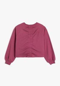 Top corto a maniche corte in mauve con cucitura posteriore arricciata e maniche raglan. Tessuto liscio con polsini e scollo a coste.