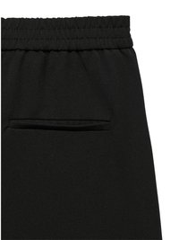 Melnas bikses ar teksturētu audumu, ar elastīgu jostasvietu un vienu kabatu aizmugurē. Dizains ir elegants un minimālistisks.