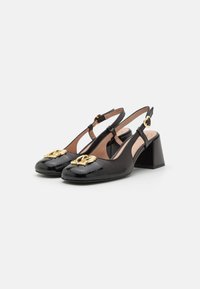 Escarpins noirs à bride arrière avec un bout en cuir verni, un talon bloc et un détail en emblème doré à l'avant. Texture lisse avec une bride réglable.