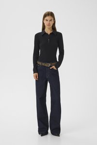 Black long-sleeve polo shirt with a collar and three-button placket, paired with dark blue wide-leg denim jeans and a brown belt.